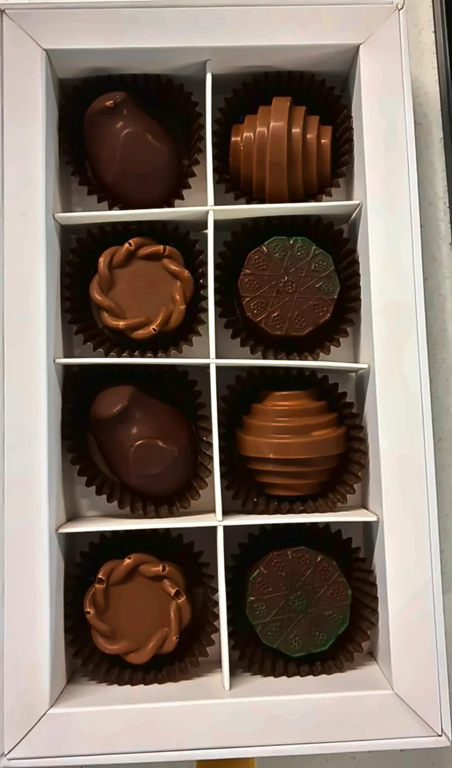 Close-up of handmade filled chocolates in a white gift box