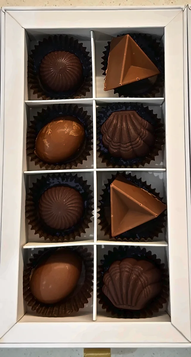 A box of eight handmade filled chocolates in brown paper cups