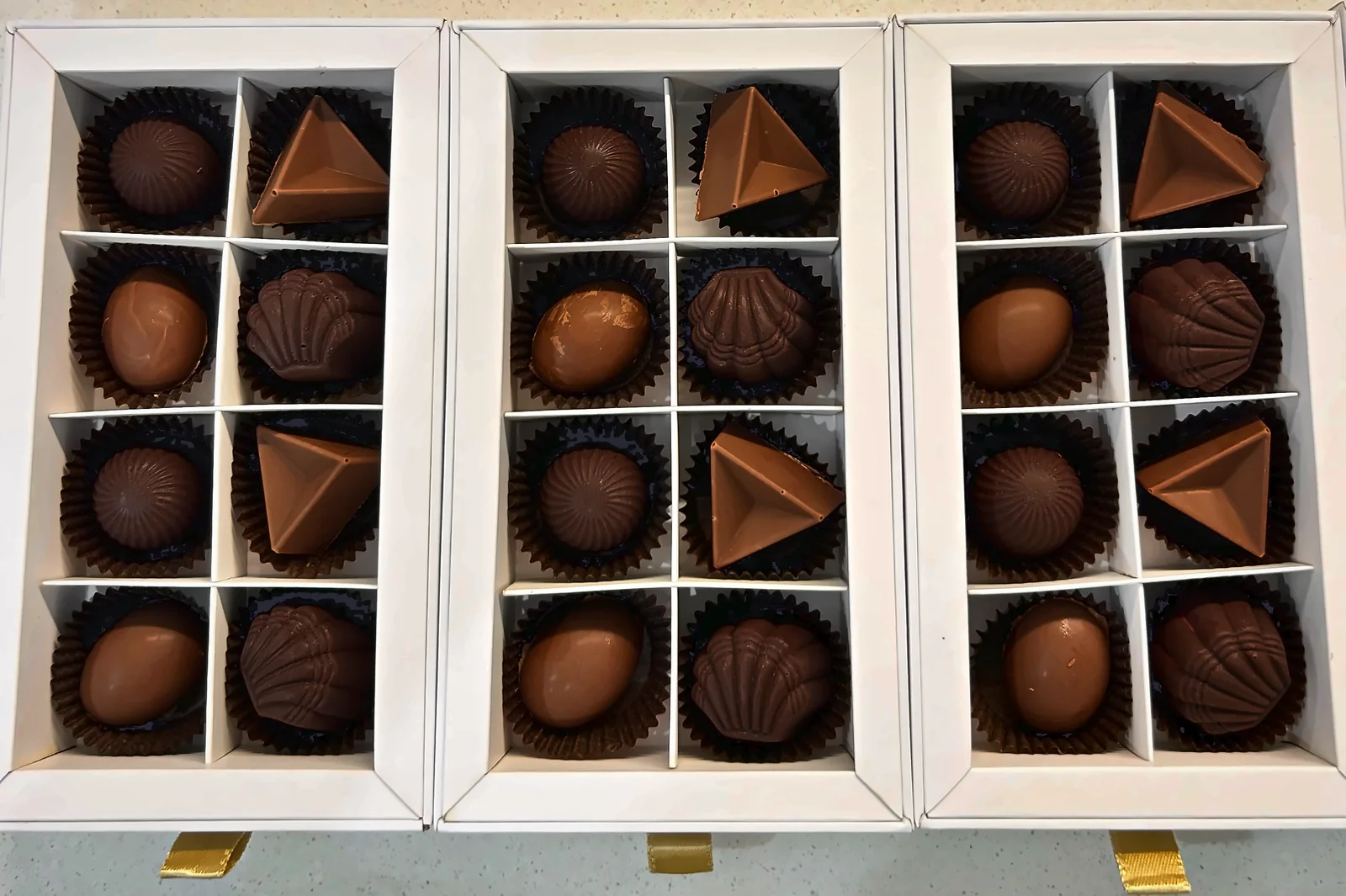 Three open gift boxes of chocolates